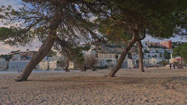Santa Ponsa beach, Mallorca at sunset with people playing in the distance.