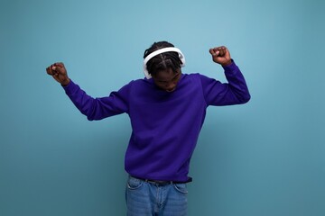 american young guy with dreadlocks listens to music with headphones