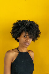 Black woman, African American beauty. Portrait of woman with afro hair. Yellow studio background.