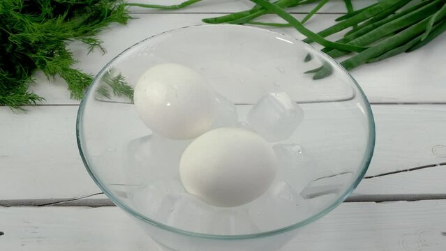 Boiled eggs are put in bowl with ice and poured.