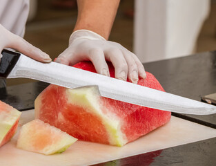 Cook slicing ripe watermelon