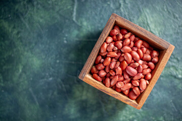 top view peeled clean peanuts on dark-blue background shell nut walnut peanut color snack cips - obrazy, fototapety, plakaty