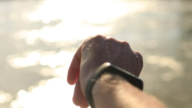 Close up of trail runner checking and preparing his watch to collect data and accompany progress before starting his training session. Athlete endurance training run exercise outdoor sports workout