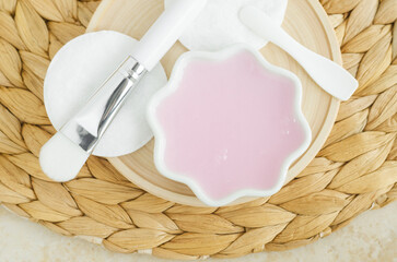 Small white porcelain bowl with rose jelly hydrating bubble mask, face moisturizer. Natural skin care concept. Top view.