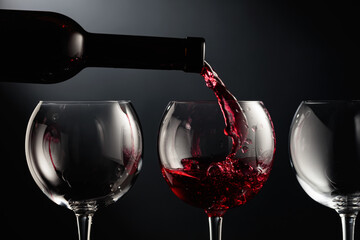 Pouring red wine into a wine glass.