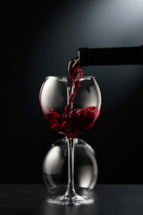 Fototapeta na wymiar Pouring red wine into a wine glass.