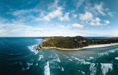 Cape Byron Bay aerial Drone View with surfers and blue sky. New South Wales, Australia.
