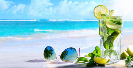 tropic summer vacation; Exotic drinks on blur tropical beach background - obrazy, fototapety, plakaty