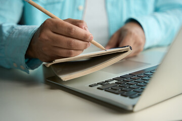 Fototapeta premium Man writing in notebook in the business center