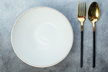 Close up shot of elegant cutlery set and white empty plate on isolated gray background with free...