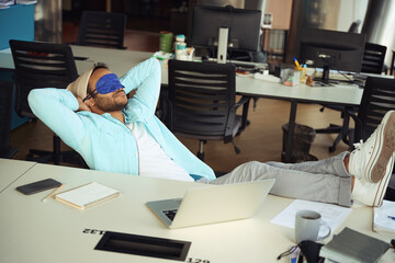 Man sleeping with his feet on the desk