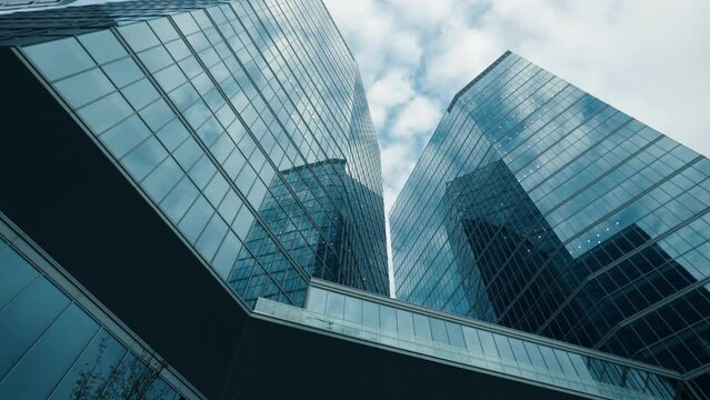 High rise skyscrapers facades low angle dolly effect, financial district looking up modern architecture office buildings, city business downtown, wide shot gimbal moving camera glide, view from below