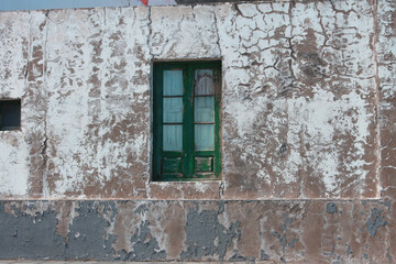 Fototapeta na wymiar green window on the old wall