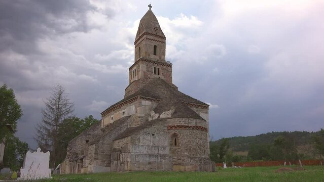 Dark clouds over the ancient Densus stone church in Romania