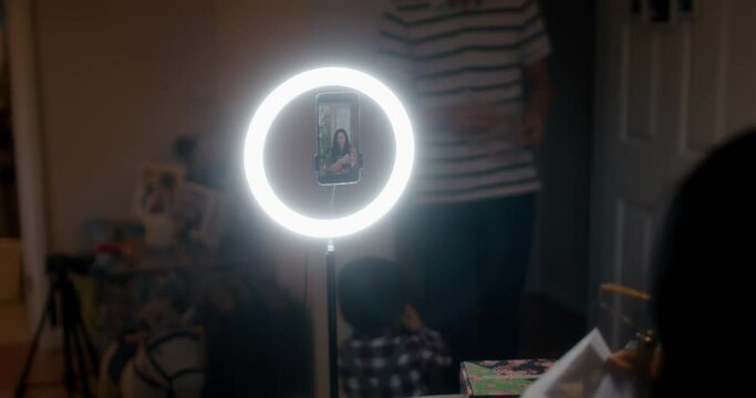 MS Father and son (18-23) watching woman recording video at home