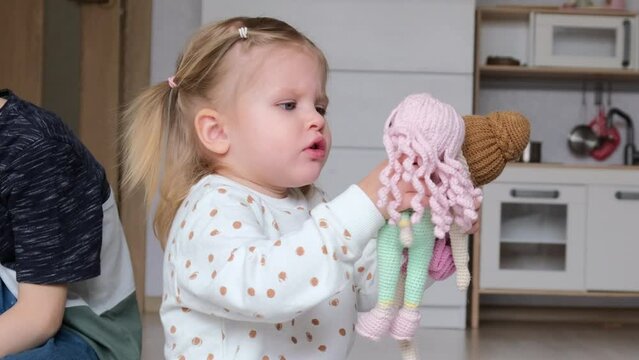 Adorable little girl playing with white dolls, Diverse kids portraits.