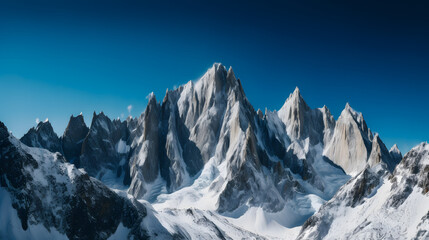 Naklejka premium A stunning landscape shot of a rocky mountain range against a deep blue sky.