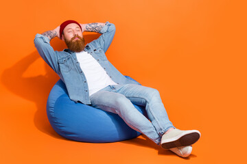 Full length photo of positive calm guy sitting bean bag chair sleeping daydreaming isolated shine...