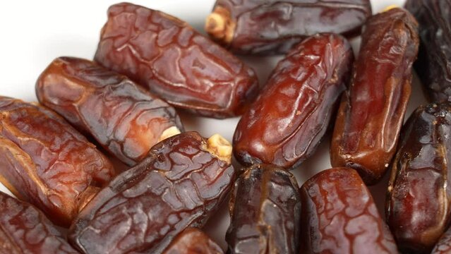 Closeup view 4k stock video footage of tasty sweet dried turkish dates isolated on white plate background. Food video background