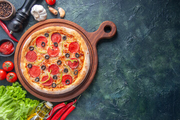 Delicious homemade pizza on wooden cutting board tomatoes ketchup green bundle garlic on the right...