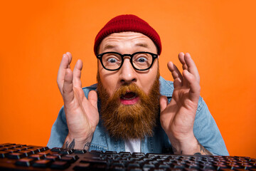 Closeup photo of website developer senior programmer man working late nights code problem stupor near keyboard isolated on orange color background