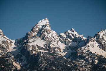 Grand Teton Mountain top close up sunny weather and blue sky. Snow capped peak. Grant Teton Nationalpark, USA.