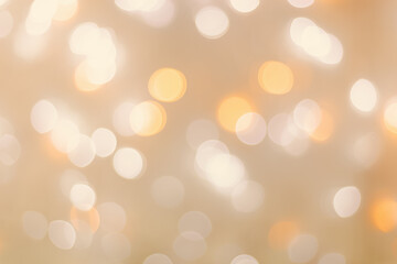 Defocused abstract bokeh background beige pastel colored, flare from lights, beige monochrome photo, blurred round bokeh as holiday fon, celebration wallpaper. Glittering aesthetic pattern