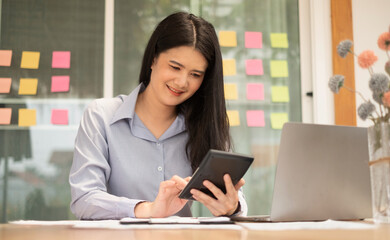 Asian businesswoman sit at their desks and calculate financial graphs showing results about their investments, plan a successful business growth process