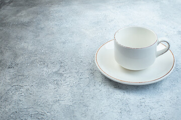 Elegant empty white cup and sauce on the left side on isolated gray background with distressed surface