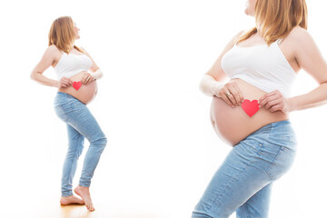 Portret nierozpoznawalnej kobiety podczas ostatnich miesięcy ciąży, trzymającej swój duży brzuch i czerwone serduszko delikatnie stojącej przy ścianie na białym tle - obrazy, fototapety, plakaty