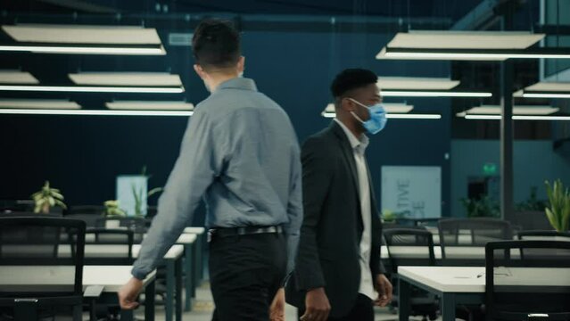 Two Male Colleagues Businessmen Meet In Office Multiracial Men Walk In Medical Mask African American Man Greet Indian Businessman In Company Non Conact Greeting Avoid Touching Hands Coronavirus Covid 