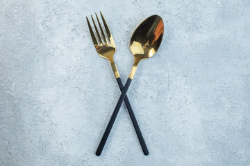 Elegant cutlery set on gray background with distressed surface with free space