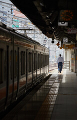 Fototapeta premium 名古屋駅のホームの電車と一人の乗客の姿
