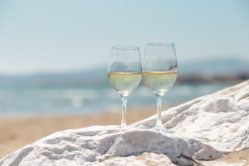 glasses of white wine on the beach