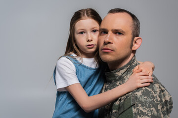 patriotic kid hugging military man in uniform and crying during memorial day isolated on grey.