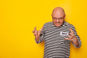 Fototapeta premium Man wearing prison uniform costume making faces