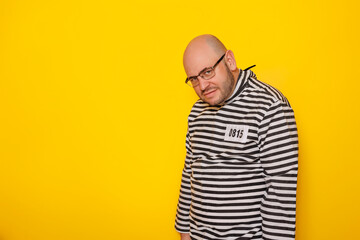 Obraz premium Man wearing prison uniform costume having fun making faces