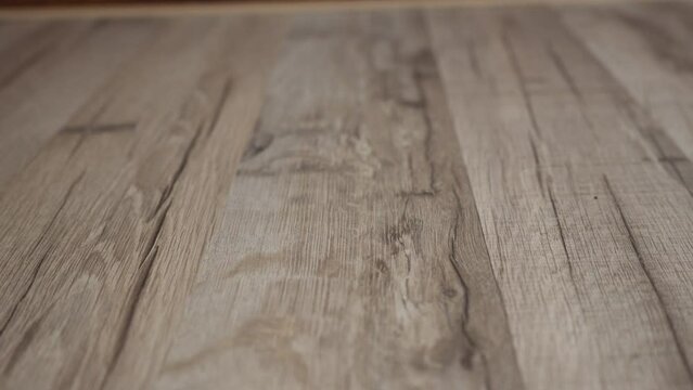 Close-up texture of light wooden parquet with natural pattern. Movement back. Part of the subject is out of focus. 