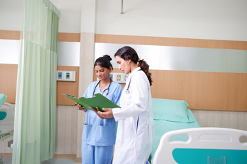 Obraz premium Asian female doctor checking a patient's record.