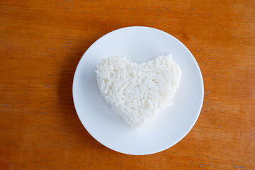 Fototapeta na wymiar heart shaped steamed rice in a white plate.