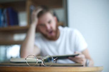 Portrait of tired overworked guy, exhausted young man in glasses college or university student is...