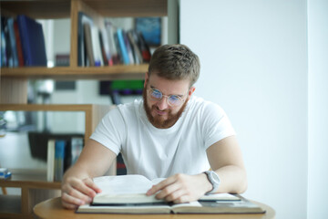 Portrait of serious concentrated guy, young man in glasses college or university student is study hard in library, prepare to exam, lesson