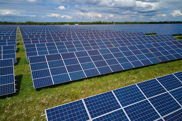 Aerial view of big sustainable electric power plant with many rows of solar photovoltaic panels for...