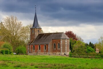 an old church building sitting across from a field of green grass