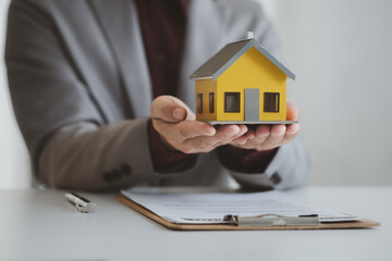 Real estate agents explain models of housing estates in projects to elaborate to clients, explaining and presenting information about homes and purchasing loans. Real estate trading concept.