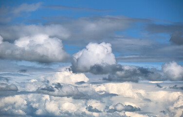 Bright landscape of white puffy cumulus clouds on blue clear sky