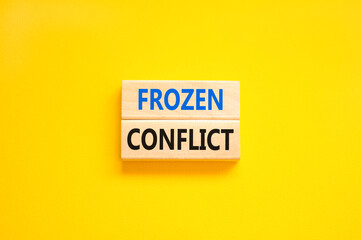 Frozen conflict symbol. Concept words Frozen conflict on beautiful wooden block. Beautiful yellow table yellow background. Business and Frozen conflict concept. Copy space.
