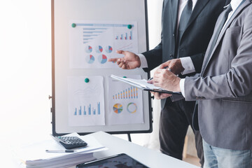 Finance and investment concept, Businessman present business finance investment plan with his partner, Investor colleagues discussing new investment plan by financial graph data on office table
