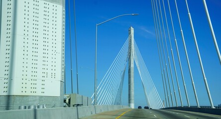 Obraz premium Minimalistic view of the modern suspension bridge structure on the background of the bright blue sky