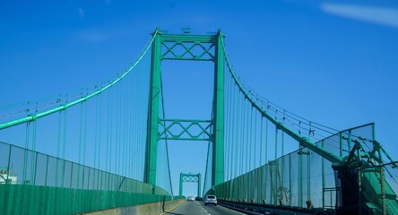 Minimalistic view of the modern suspension bridge structure on the background of the bright blue sky